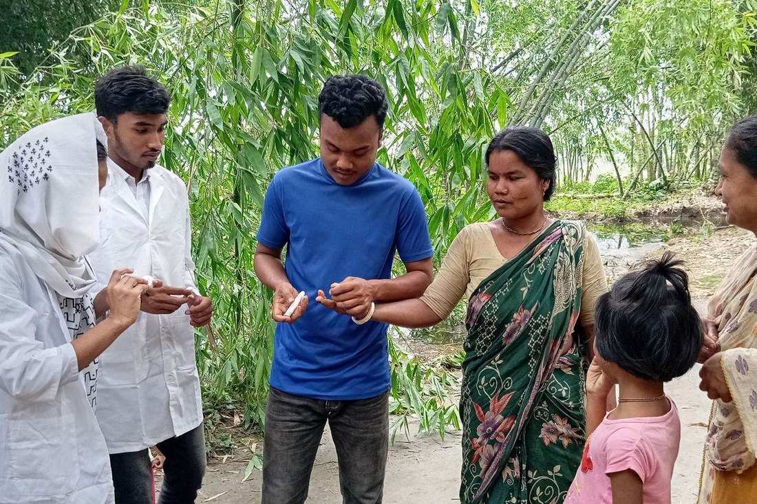 An OfP health worker testing a villager during a community health visit