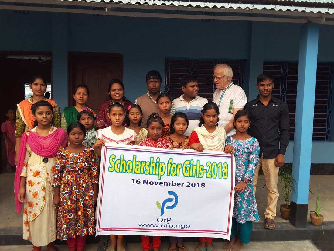 Girls holding an OfP Scholarship for Girls banner with OfP staff