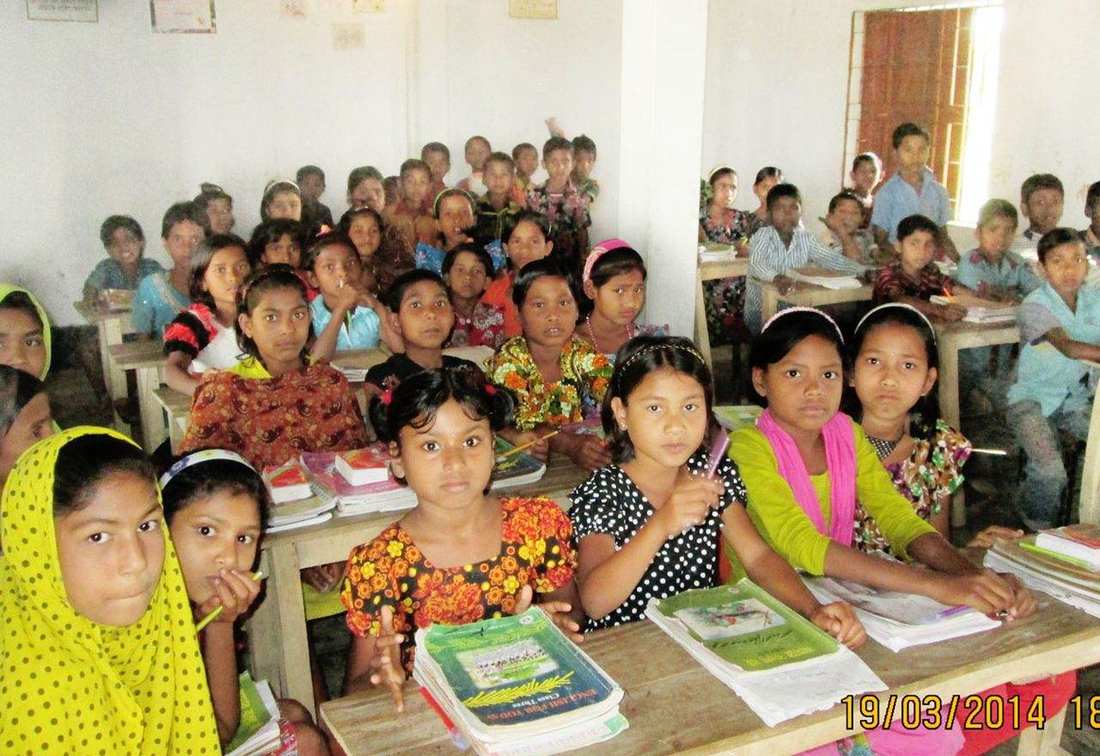 A full classroom of OfP students at their desks with books