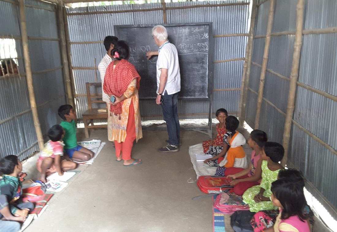 Children learning on mats inside a tin-shed OfP classroom