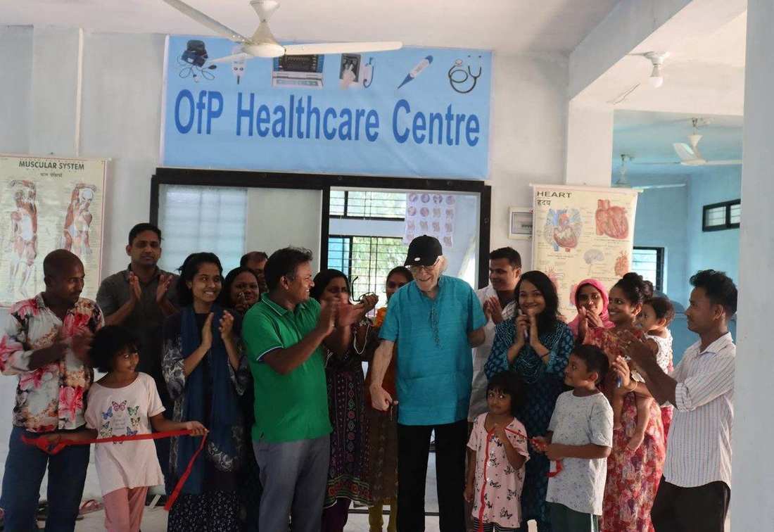 A health worker checking a young woman's blood pressure at the OfP Healthcare Centre